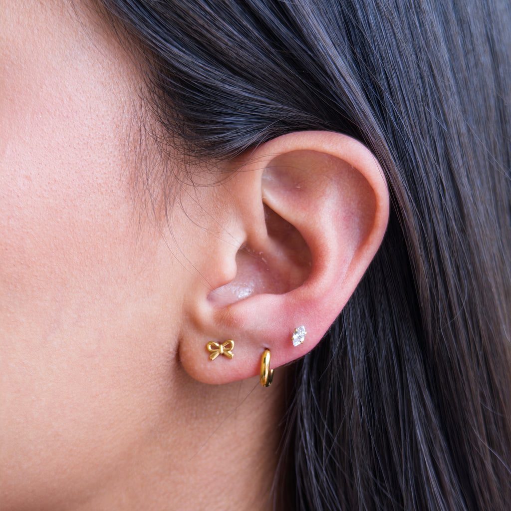Piercings de Acero con Moño Dorado en Relieve